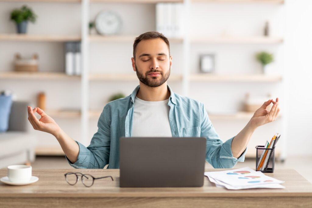 Mann meditiert vor Laptop im Arbeitszimmer | Vuse Epod