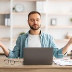 Mann meditiert vor Laptop im Arbeitszimmer | Vuse Epod