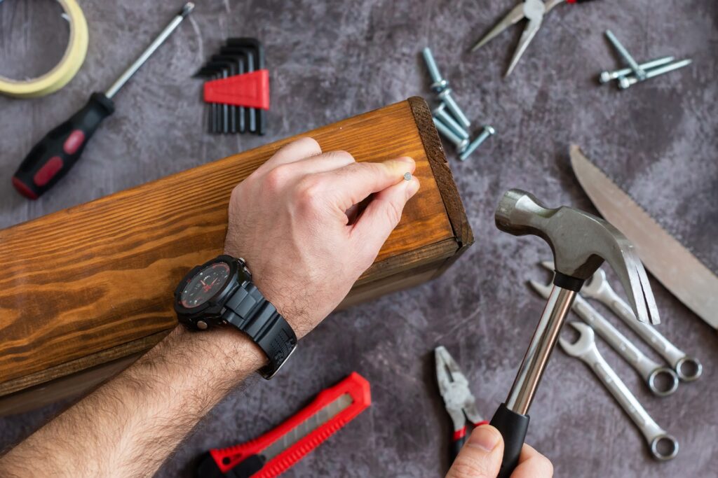 Handwerker bearbeitet Holz mit Hammer | Terrassenüberdachung Frankfurt