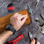 Handwerker bearbeitet Holz mit Hammer | Terrassenüberdachung Frankfurt